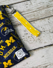 Load image into Gallery viewer, Blue and yellow University of Michigan pattern travel diaper bag with key FOB and changing pad.