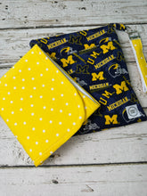 Load image into Gallery viewer, Blue and yellow University of Michigan pattern travel diaper bag with key FOB and changing pad.
