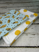 Load image into Gallery viewer, Set of 2 burp cloths.  One is blue with yellow Winnie Pooh.  Other is white with large yellow polka dots.
