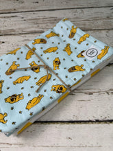 Load image into Gallery viewer, Set of 2 burp cloths.  One is blue with yellow Winnie Pooh.  Other is white with large yellow polka dots.
