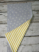 Load image into Gallery viewer, a gray burp cloth with yellow daisies showing the back side of yellow and white stripes
